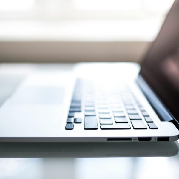 Free Elegant side view of a laptop on a glossy table with natural lighting indoors. Stock Photo